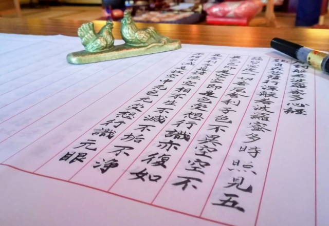 お寺で静かに写経を行うイメージ