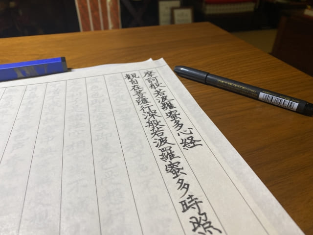 写経用紙と筆ペンが置かれた机の上